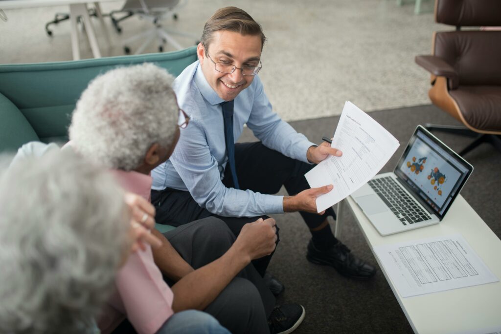 pexels photo 8441811 8441811 Financial advisor discussing documents with senior clients in an office setting, showcasing a collaborative consulting session.